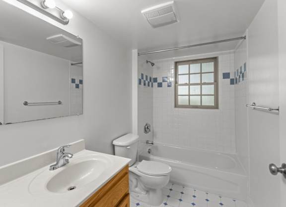 A white bathroom with a sink, toilet, and bathtub.