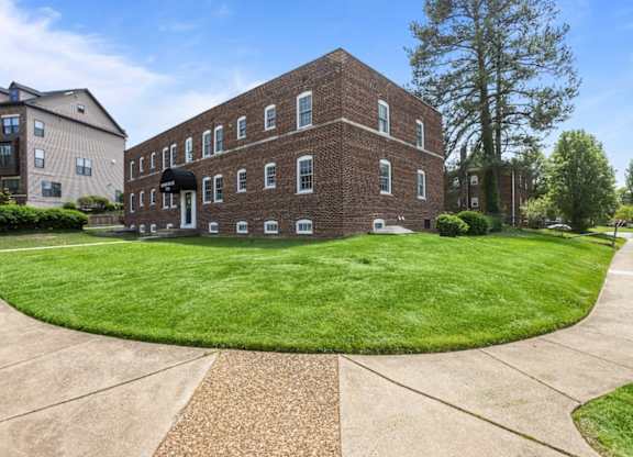A red brick building with a green lawn in front.