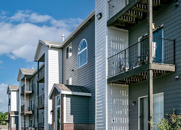 A row of modern townhouses with balconies and garages.