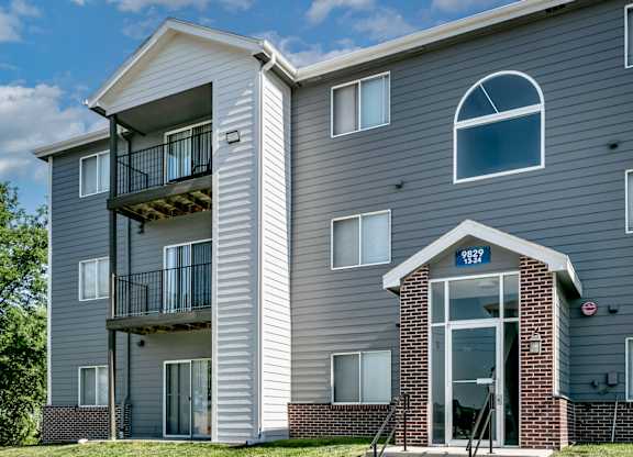 A grey apartment building with the number 8222 on the front door.