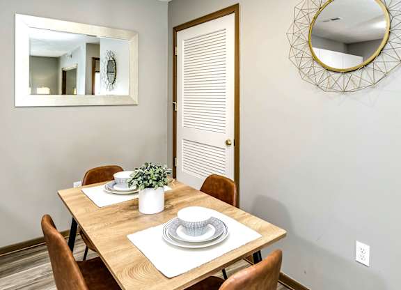 A dining room with a wooden table set for two.