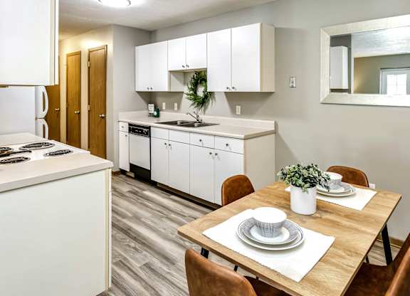 A kitchen with a dining table set for two.