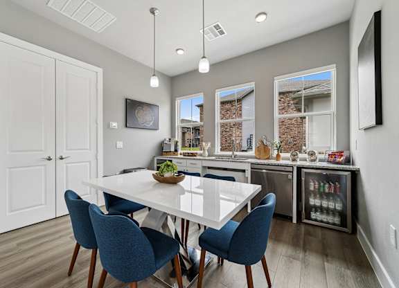 A dining room with a white table and blue chairs.