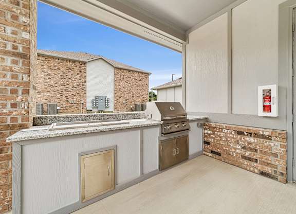 A kitchen area with a brick wall and a wooden door.