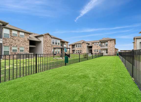 A row of houses with a green lawn in front.
