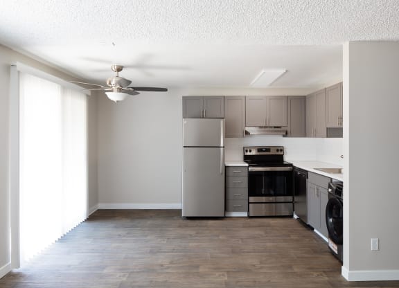 a kitchen with stainless steel appliances and a ceiling fan
