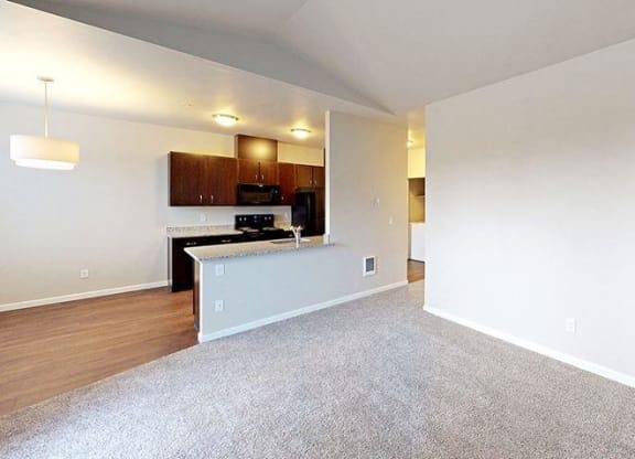 an empty room with a kitchen and a living room