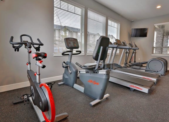 a home gym with exercise equipment and windows
