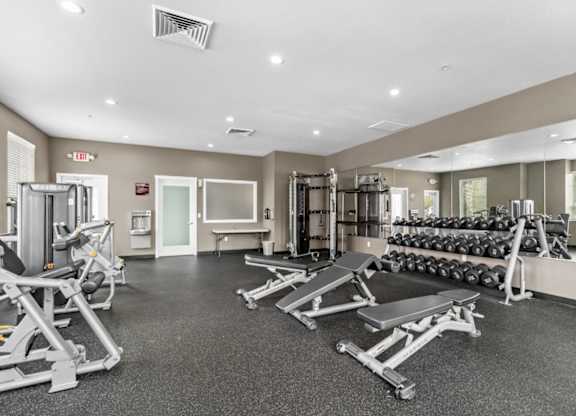 A spacious gym with a variety of equipment including treadmills, weights, and exercise machines.