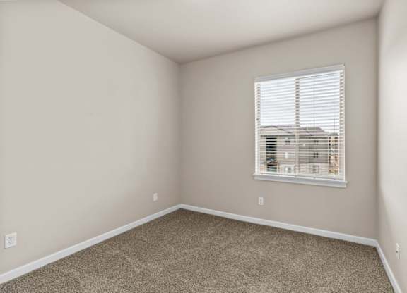 A room with a window and carpeted floor.
