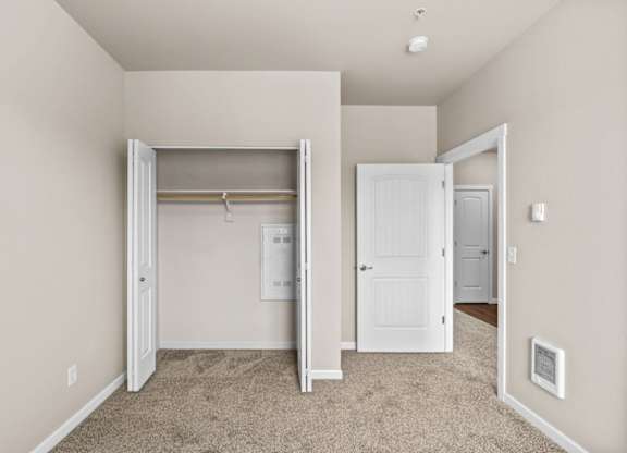 A room with a carpeted floor and a white door.