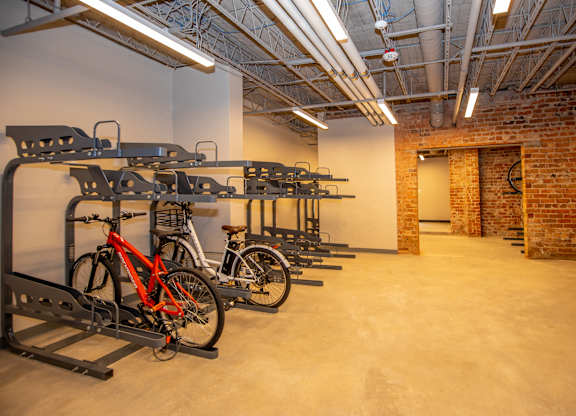 A room with a brick wall and a bike rack.