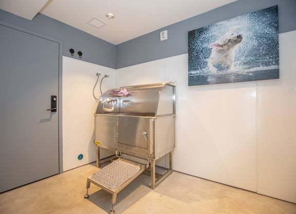 A large metal box with a glass door and a step ladder is in a room with a painting of a polar bear on the wall.