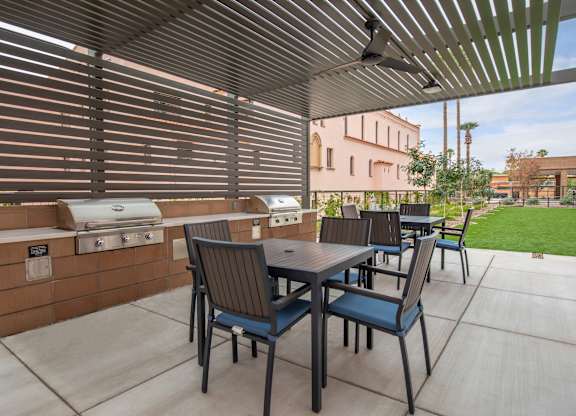 A patio with a table and chairs under a pergola.