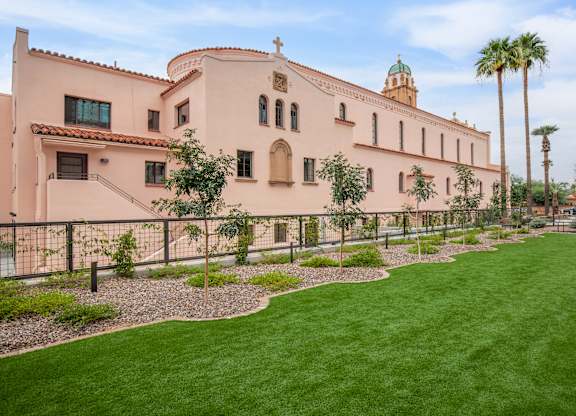 A church with a green lawn in front.