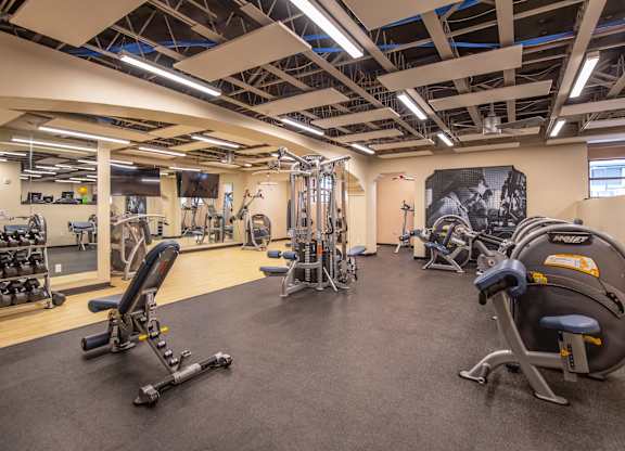 A gym with a variety of equipment including weights and machines.