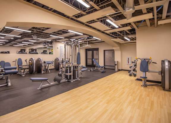 A gym with a variety of equipment including weights and machines.