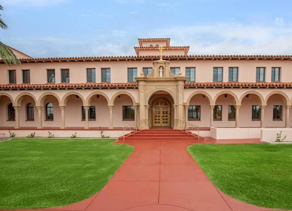 A large building with a red walkway leading to the entrance.
