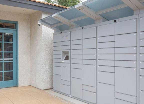 A series of mailboxes are lined up on the side of a building.