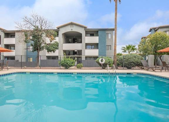 A swimming pool in front of apartment buildings.