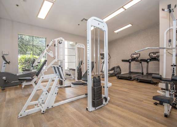 A gym with a variety of equipment including a leg press machine.