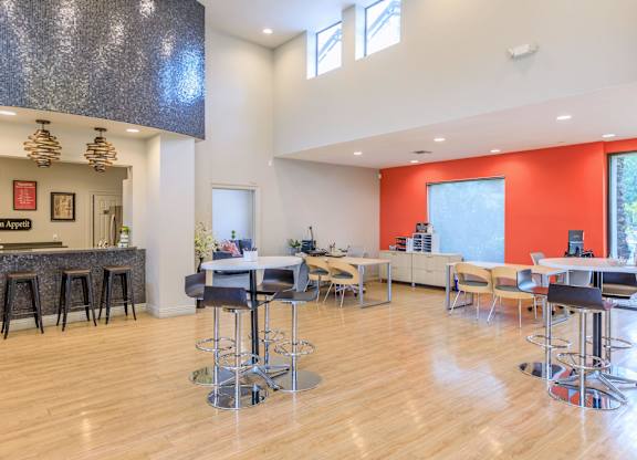 A modern kitchen with a bar area and a dining table.