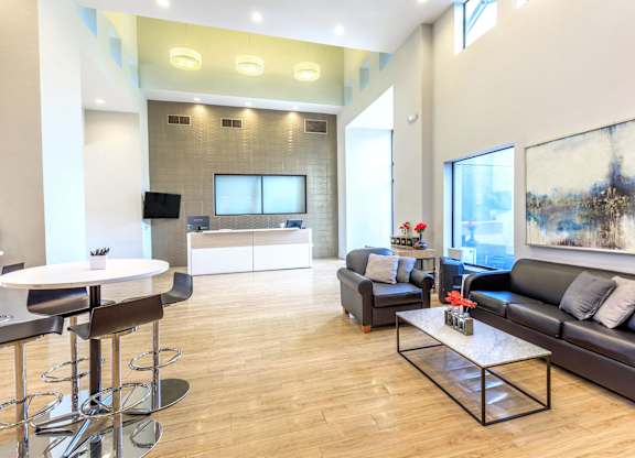 A modern living room with a black leather couch and a white coffee table.