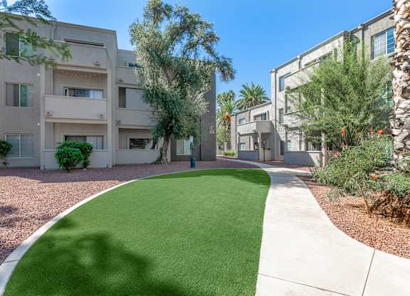 A grassy area in front of apartment buildings.