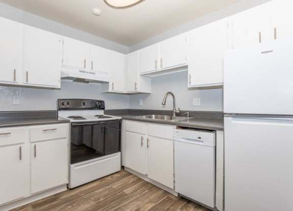 A modern kitchen with white cabinets and stainless steel appliances.