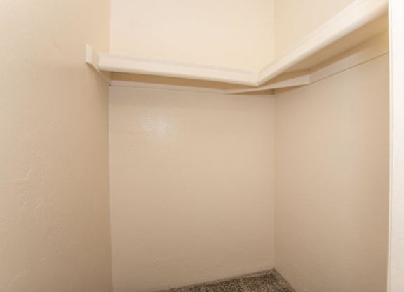 A small, empty room with a white ceiling and a carpeted floor.