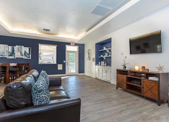 A living room with a brown leather couch and a wooden entertainment center.