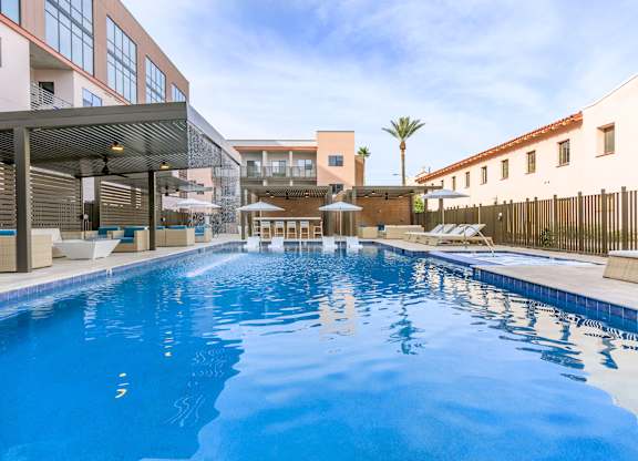A large indoor swimming pool with a sunny day outside.