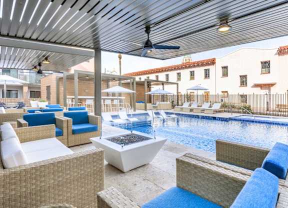 A patio with a pool and a ceiling fan.