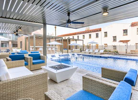 A patio with a pool and a ceiling fan.