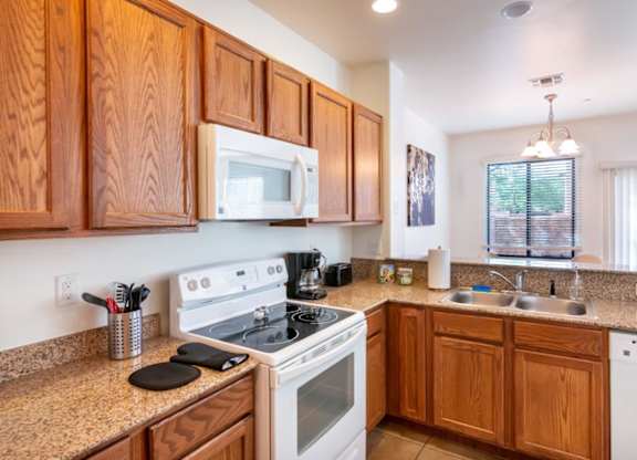A kitchen with wooden cabinets and a white stove top oven.