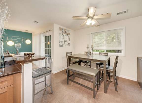 A kitchen with a dining table and chairs.