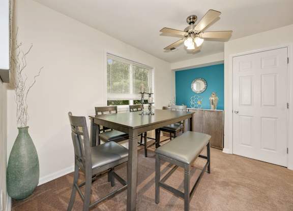 A dining room with a table and chairs.