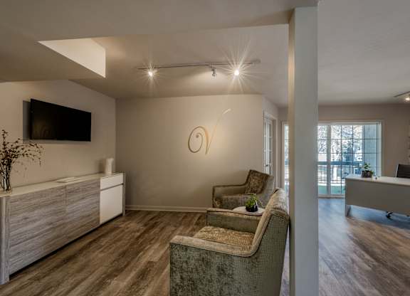 A modern living room with a grey sofa and a wooden cabinet.