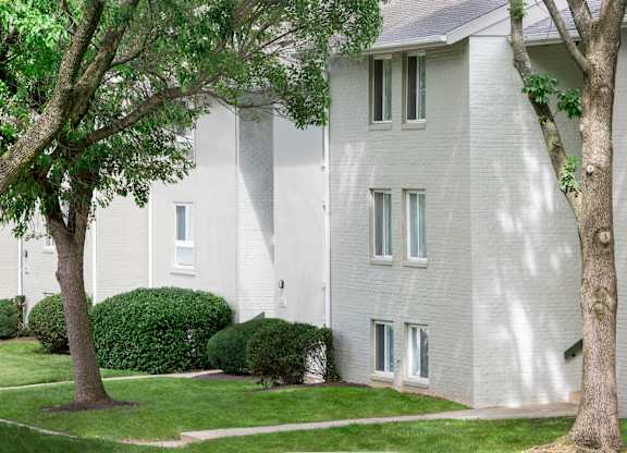 A white building with a tree in front of it.