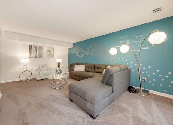 A living room with a grey sofa and a white coffee table.