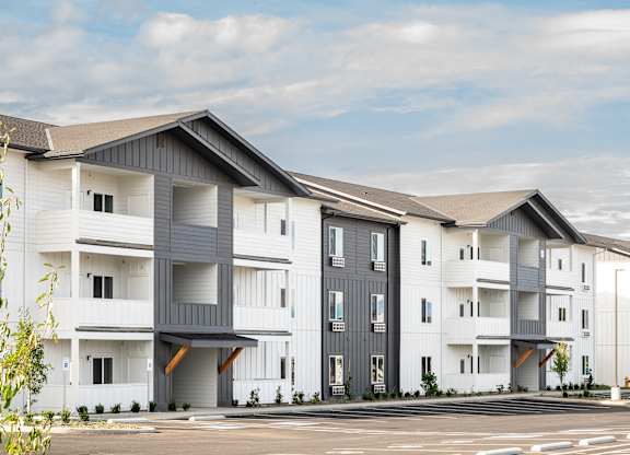 A modern apartment complex with white and grey buildings.