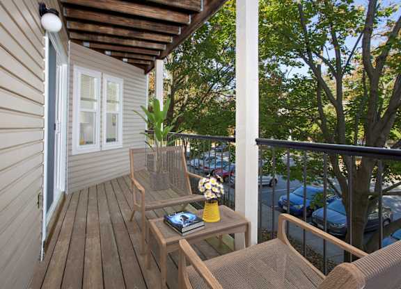 A balcony with a table and chairs overlooking a parking lot.