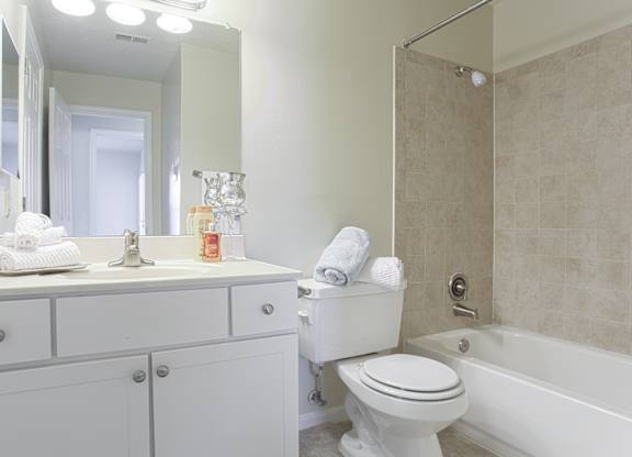 A white bathroom with a toilet, sink, and bathtub.