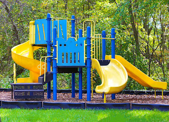 A playground with a blue and yellow slide.