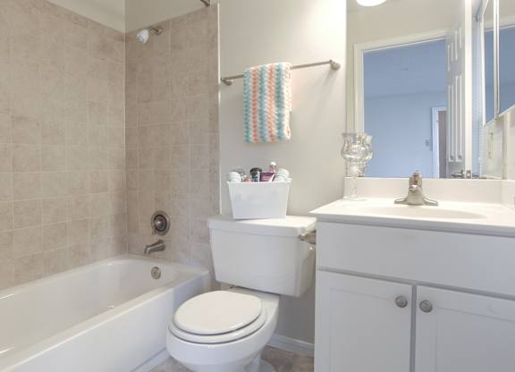 A white toilet sits next to a bathtub in a bathroom.