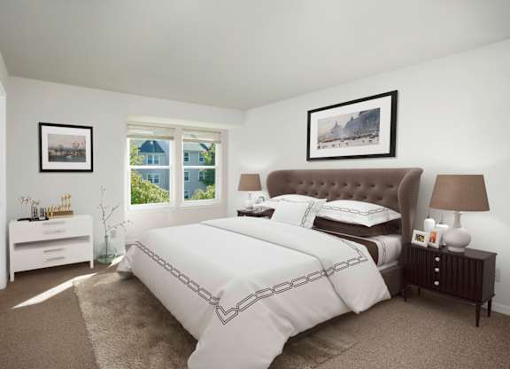 A bedroom with a large bed and a window overlooking a blue house.