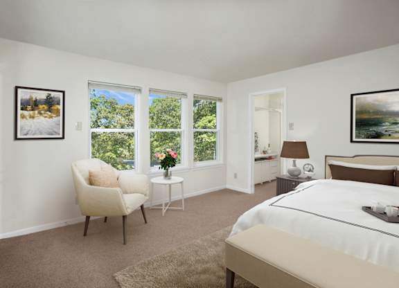 A bedroom with a large bed, a chair, and a painting on the wall.