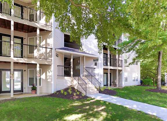 Apartment building with a tree in front.