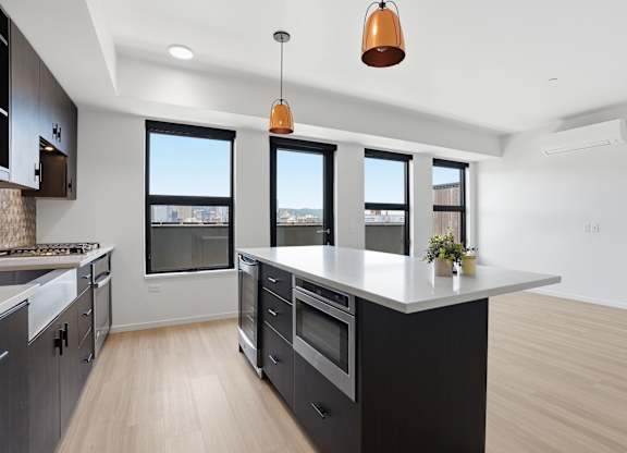 A modern kitchen with a large island and a view of the city.
