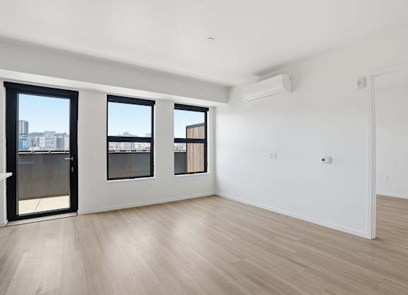 A room with a sliding door, a window, and a wall-mounted air conditioner.